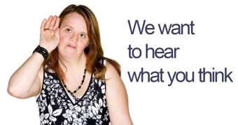 A young woman with intellectual disability cups her hand to her ear to listen to what people are saying